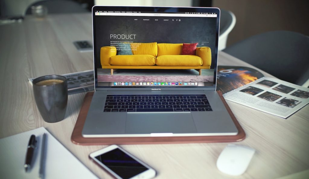 turned on macbook pro beside gray mug